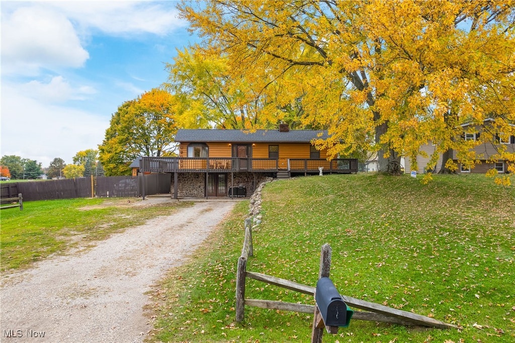 view of front of house with a wooden deck and a front yard