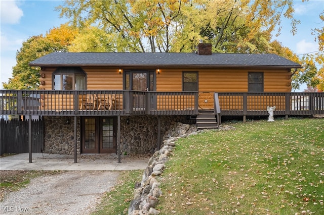 rear view of house featuring a deck and a yard