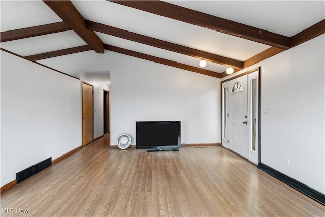 unfurnished living room featuring light hardwood / wood-style flooring and lofted ceiling with beams