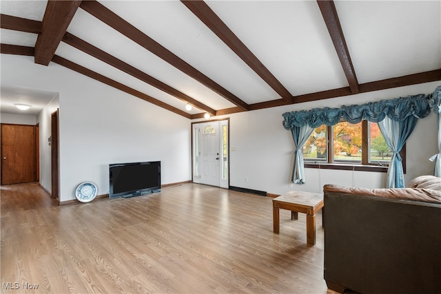 living room featuring vaulted ceiling with beams and light wood-type flooring