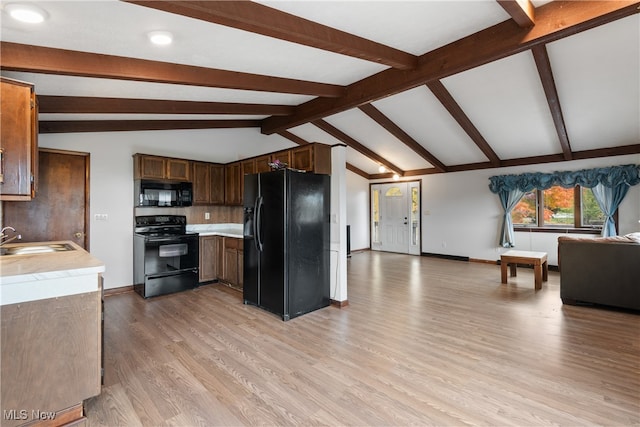 kitchen featuring sink, black appliances, lofted ceiling with beams, and light hardwood / wood-style floors