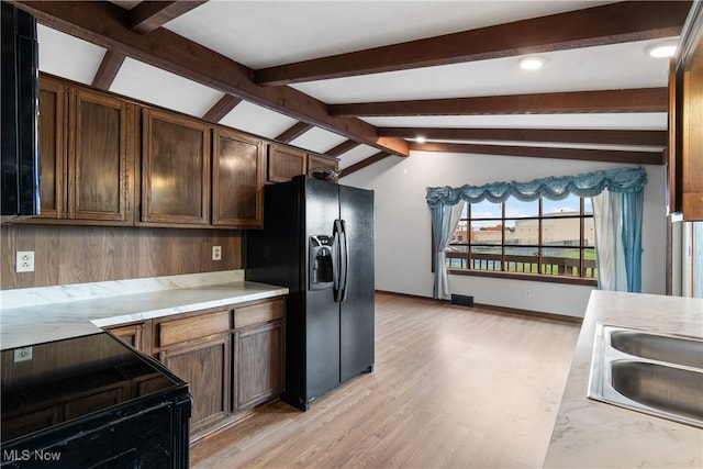 kitchen featuring vaulted ceiling with beams, dark brown cabinets, sink, black appliances, and light hardwood / wood-style floors