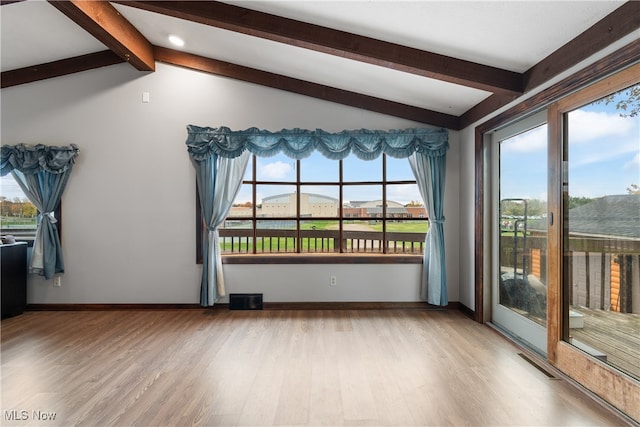 interior space featuring light hardwood / wood-style flooring and lofted ceiling with beams