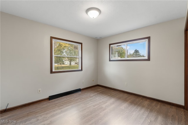 empty room featuring light hardwood / wood-style floors and a textured ceiling