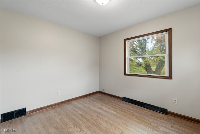 spare room featuring light hardwood / wood-style floors and a baseboard radiator