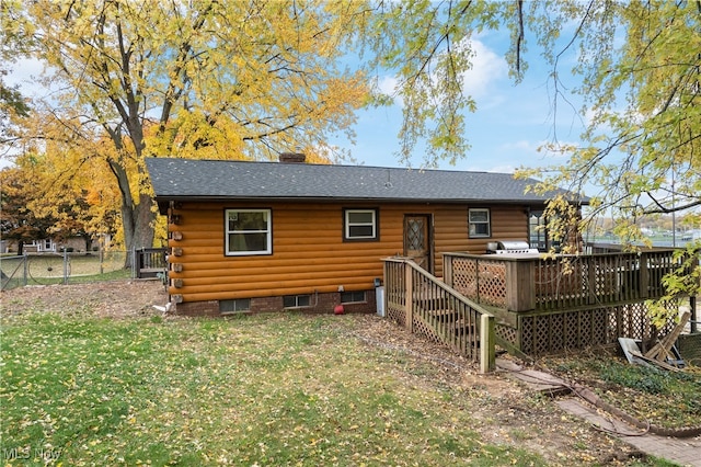 rear view of property featuring a wooden deck and a yard