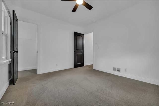 carpeted spare room with ceiling fan