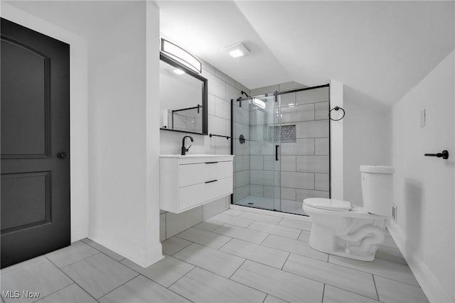 bathroom featuring toilet, vanity, vaulted ceiling, and a shower with shower door