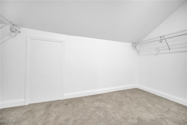 walk in closet with carpet and lofted ceiling