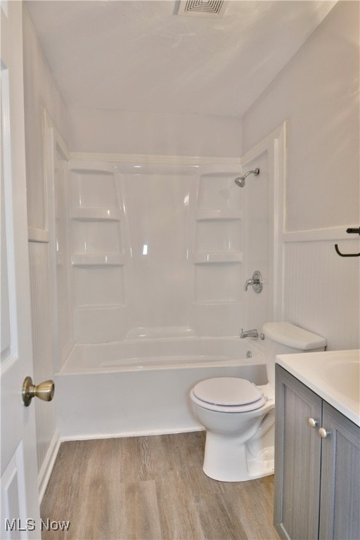 full bathroom featuring toilet, shower / washtub combination, hardwood / wood-style flooring, and vanity