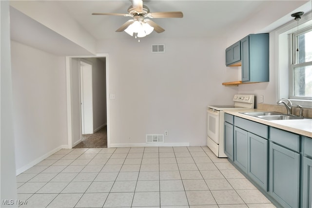 kitchen featuring ceiling fan, light tile patterned floors, blue cabinetry, electric stove, and sink