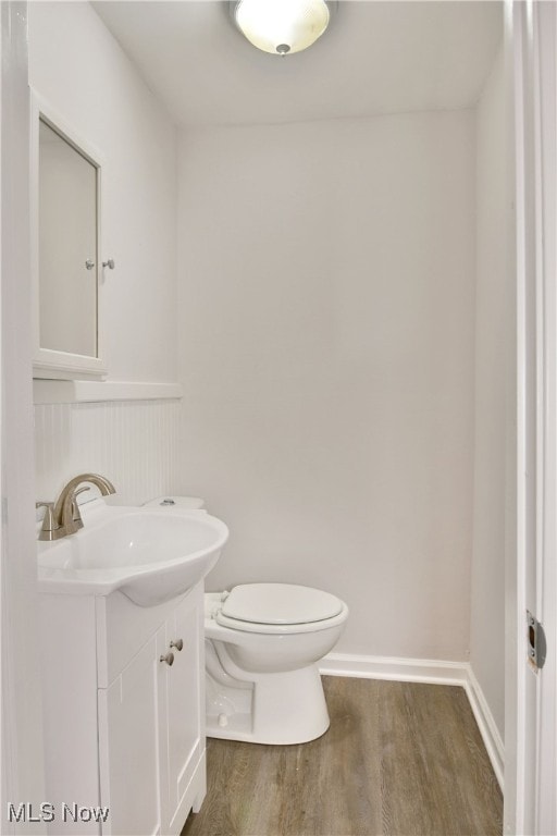 bathroom with vanity, hardwood / wood-style flooring, and toilet