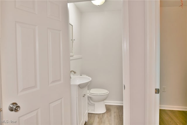 bathroom featuring vanity, wood-type flooring, and toilet