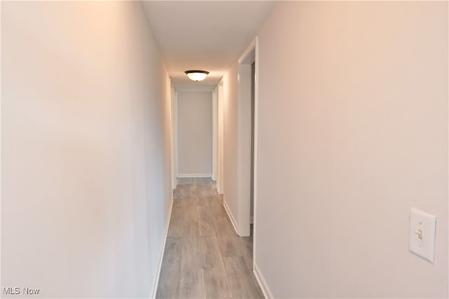 hallway with light hardwood / wood-style floors