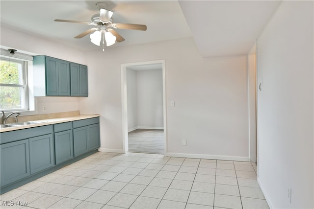 kitchen with sink, light tile patterned floors, and ceiling fan