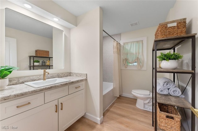 full bathroom featuring vanity, wood-type flooring, shower / bath combo, and toilet