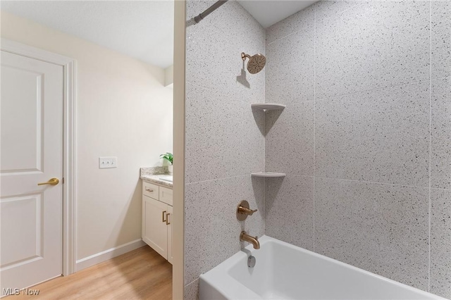 bathroom featuring vanity, wood-type flooring, and shower / bathtub combination