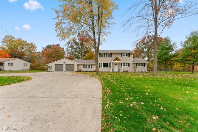 colonial-style house featuring a front lawn and a garage