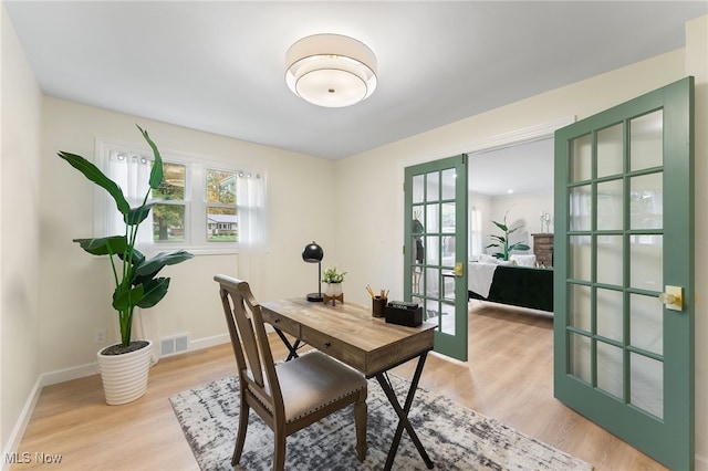 office area with light wood-type flooring and french doors