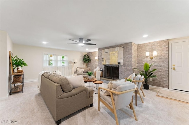 living room featuring a fireplace, light carpet, ceiling fan, and brick wall