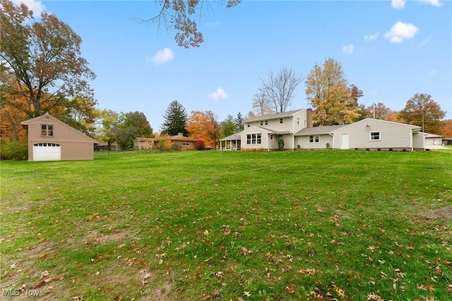 view of yard featuring a garage and an outbuilding