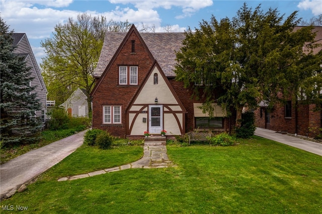 english style home featuring a front yard