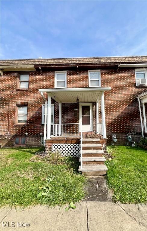 1208 N 4th St, Toronto, OH 43964 - view of front of home featuring brick siding, covered porch, cooling unit, and a front lawn