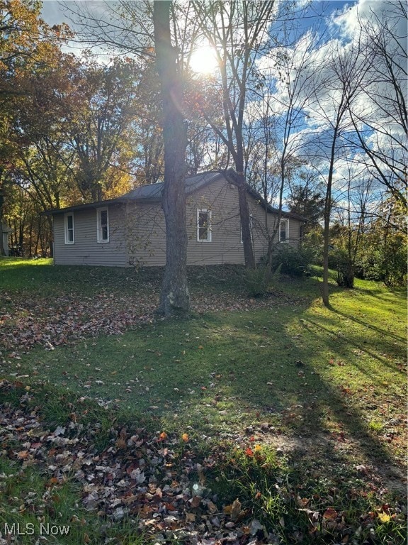 view of side of home featuring a lawn