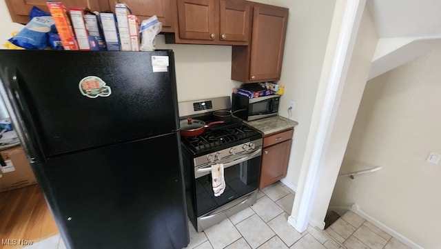 kitchen with appliances with stainless steel finishes and light tile patterned floors