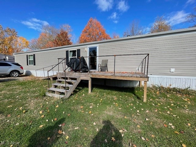 back of house featuring a wooden deck and a lawn