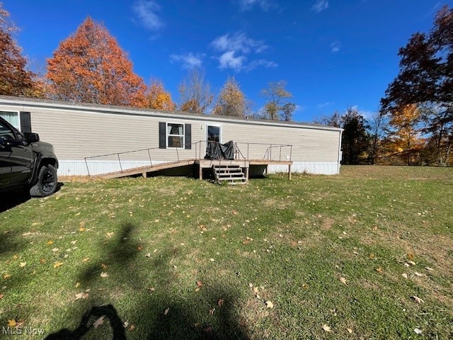 back of property with a yard and a wooden deck