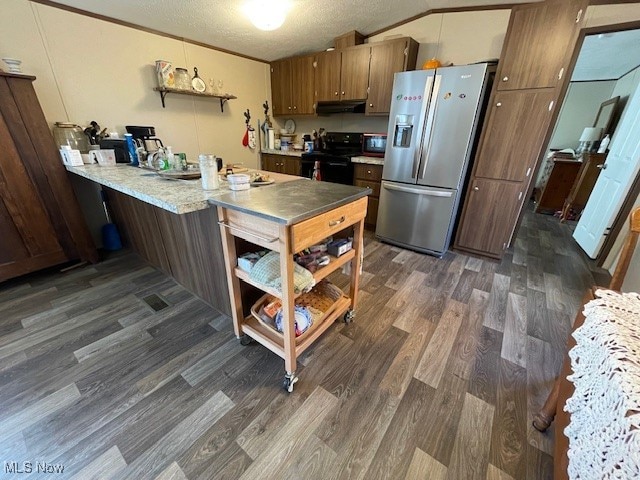 kitchen with lofted ceiling, kitchen peninsula, dark hardwood / wood-style flooring, a textured ceiling, and black appliances