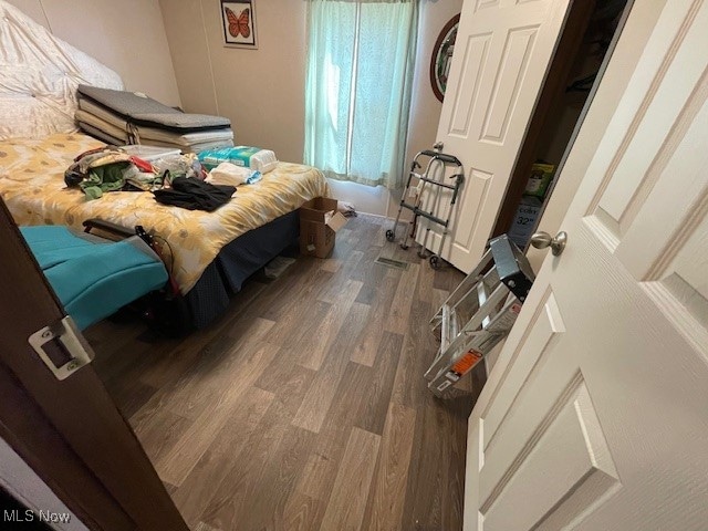 bedroom with dark hardwood / wood-style flooring