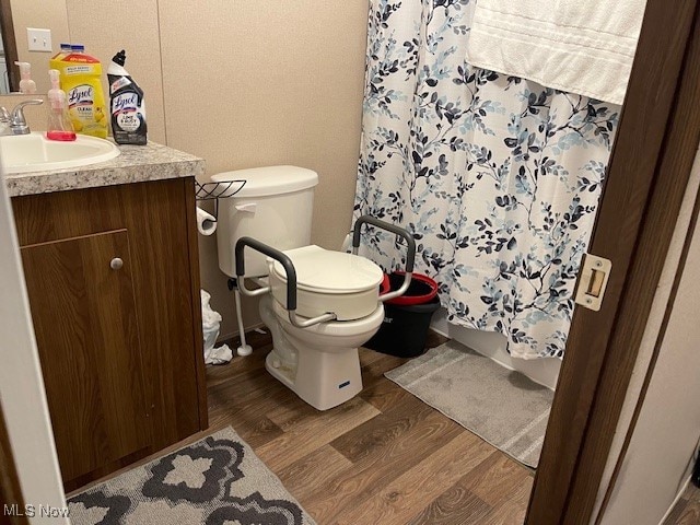 bathroom with vanity, toilet, a shower with curtain, and hardwood / wood-style floors