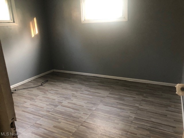 spare room featuring light hardwood / wood-style flooring and plenty of natural light