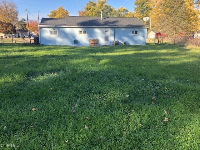 rear view of property featuring a lawn