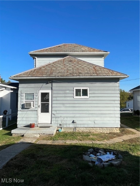 rear view of house with a yard and cooling unit