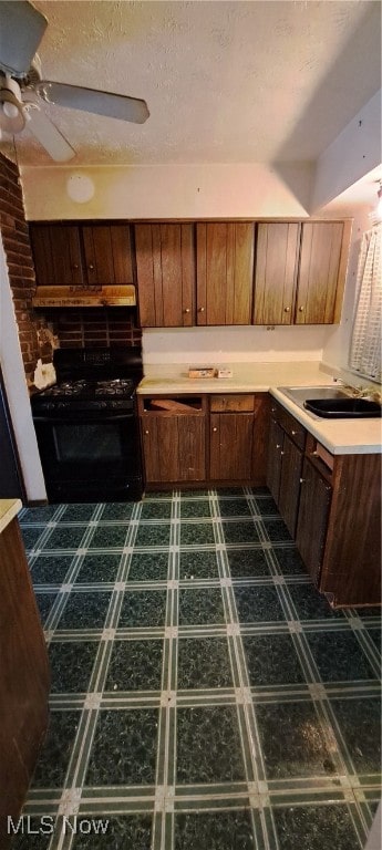 kitchen featuring sink, black range oven, a textured ceiling, and ceiling fan