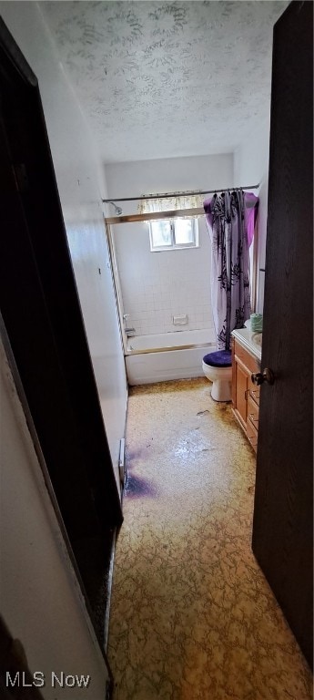 full bathroom with toilet, a textured ceiling, shower / tub combo with curtain, and vanity