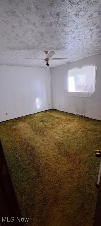 carpeted spare room featuring a textured ceiling and ceiling fan