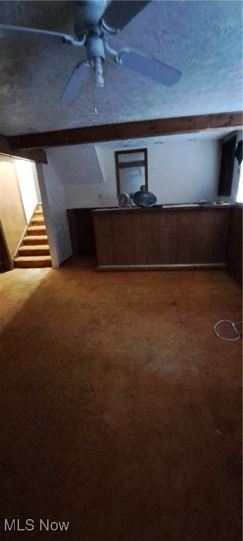 bonus room featuring wood walls, carpet flooring, and ceiling fan