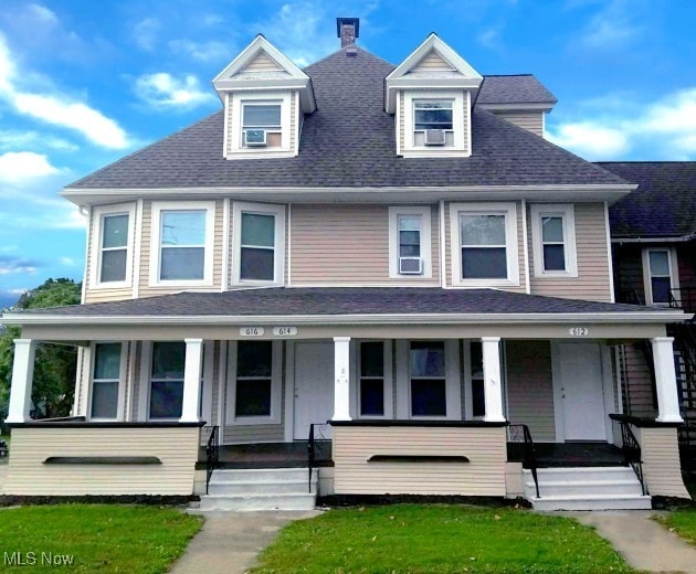 view of front of property with covered porch and a front yard