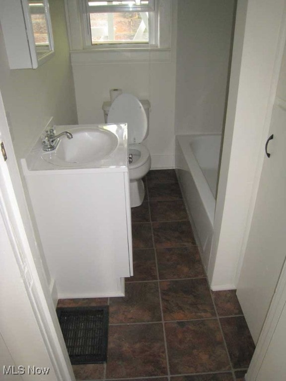 bathroom with vanity, toilet, tile patterned flooring, and a bathing tub