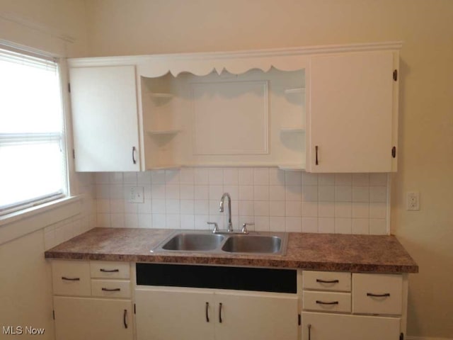 kitchen featuring white cabinetry, backsplash, and sink