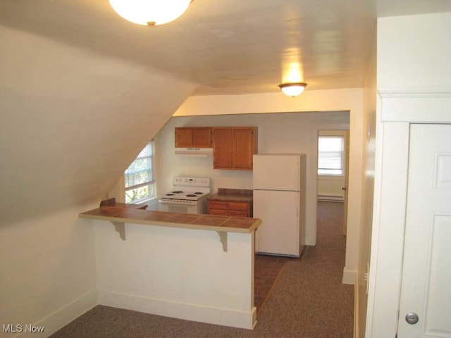 kitchen with tile countertops, kitchen peninsula, a healthy amount of sunlight, a breakfast bar, and white appliances