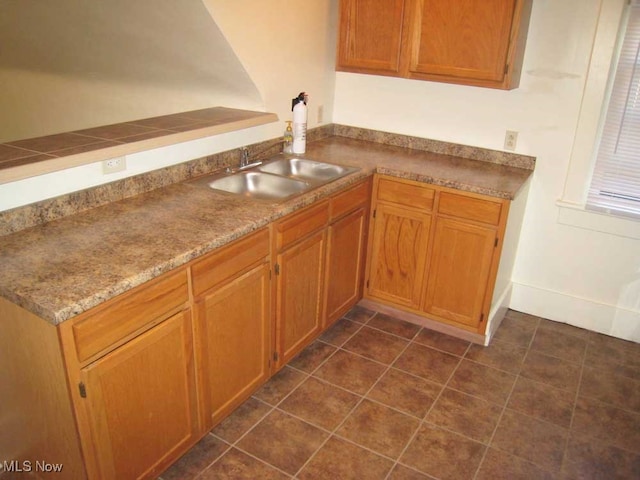 kitchen with dark tile patterned floors and sink