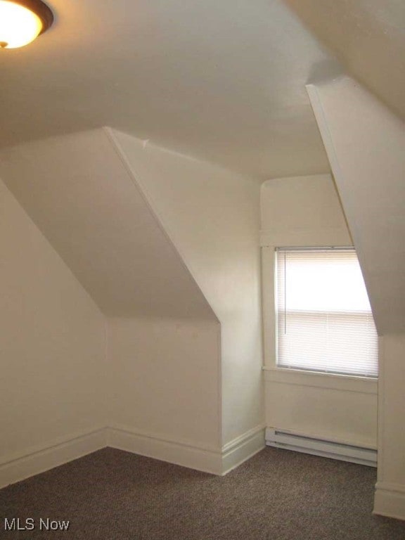 bonus room featuring lofted ceiling, a baseboard heating unit, and dark carpet