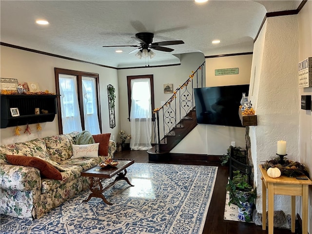 living room featuring ceiling fan, dark hardwood / wood-style floors, a textured ceiling, and crown molding