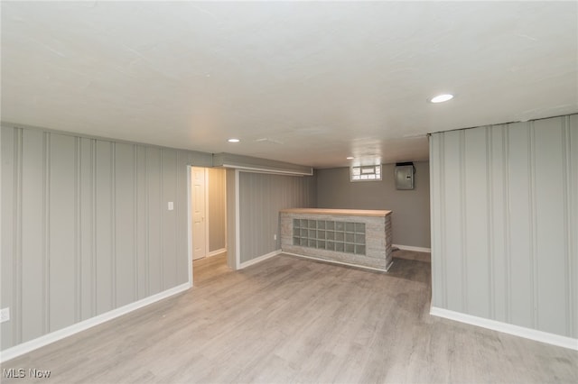 basement featuring a fireplace and light wood-type flooring