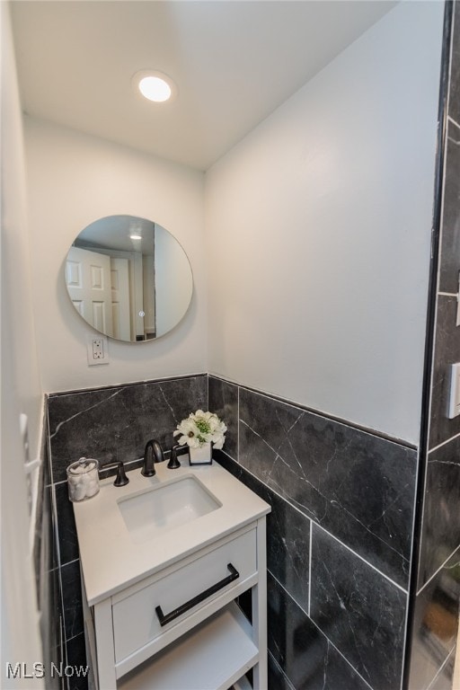 bathroom featuring vanity and tile walls